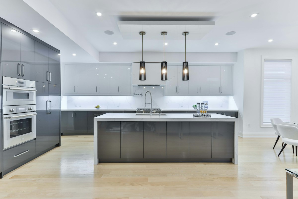 A modern kitchen with grey cabinets and a white island